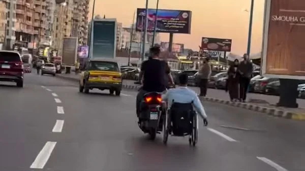 مثال للجدعنة: شاب يدعم صديقه على الكرسي المتحرك